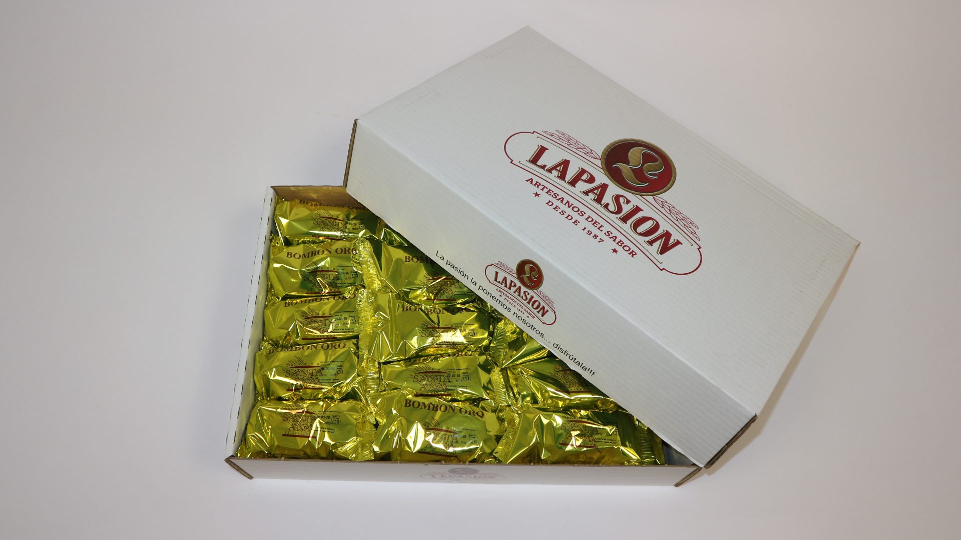 Bombón de bizcocho Oro de La Pasión, cubierta brillante de chocolate y corazón esponjoso.