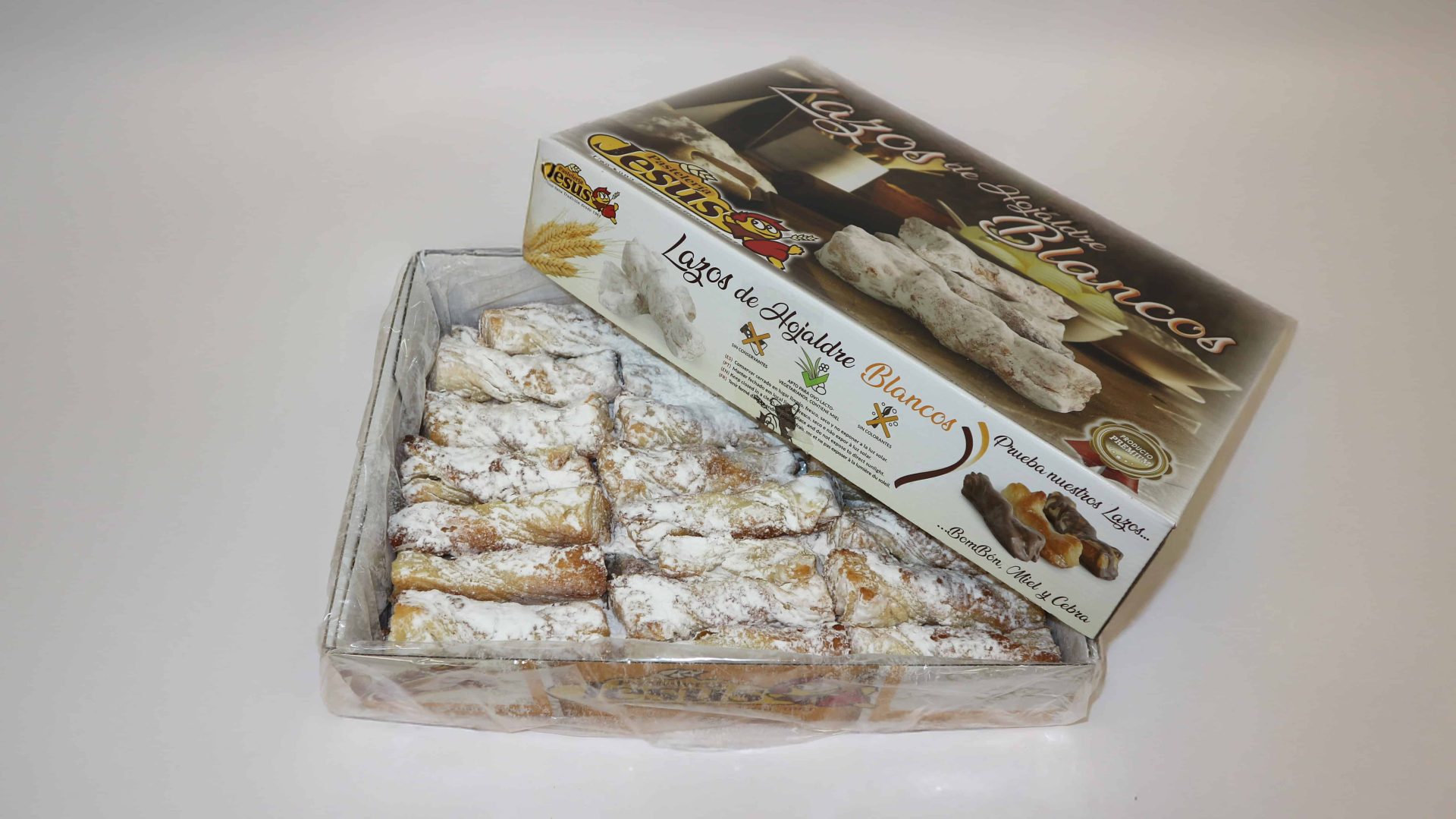 Lazo blanco de hojaldre de Pastelería Jesús, crujiente y cubierto de glaseado dulce.