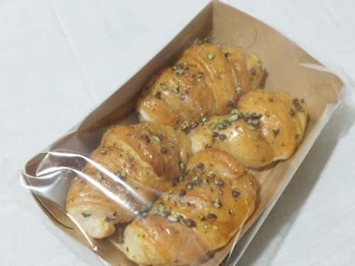 Croissant de crema de pistacho Belcan, hojaldre relleno con grageas troceadas por encima