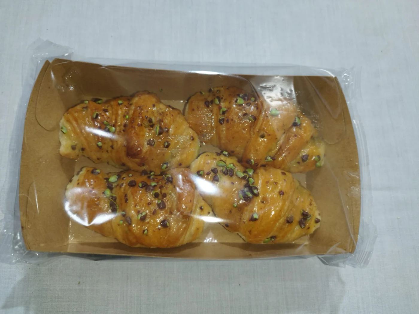 Flow pack de 4 croissants de crema de pistacho Belcan sobre la mesa